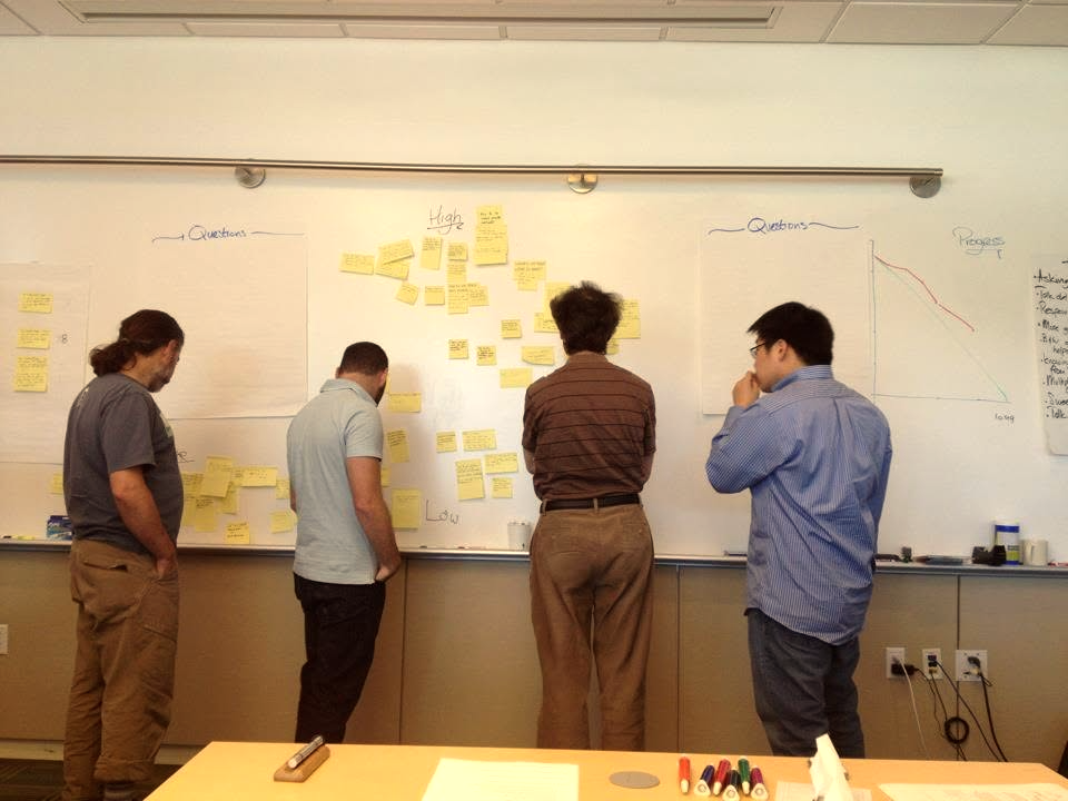 Greg Burch planning with the team at a whiteboard